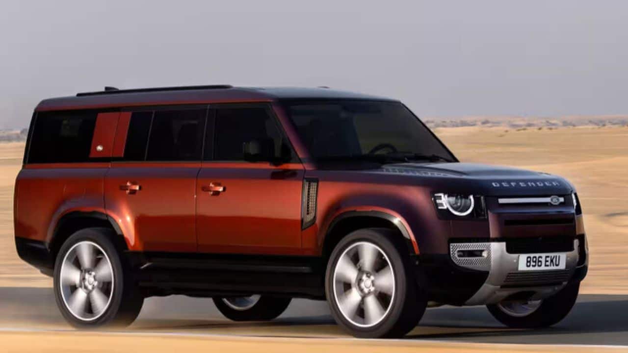 Land Rover Defender driving on rugged terrain highlighting its off-road capability and upright design
