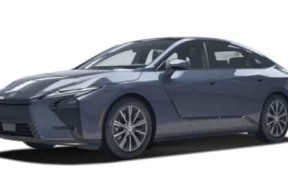 New-generation Lexus ES 350h hybrid sedan parked outdoors, shown from the front three-quarter angle, showcasing its Z-shaped LED headlamps.