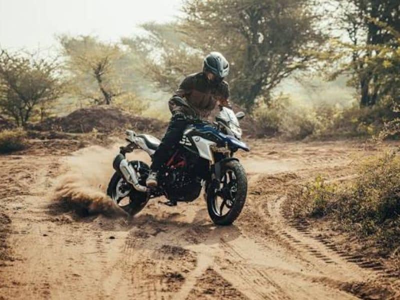 Adventure motorcycle on an unpaved rural road showing off-road capability