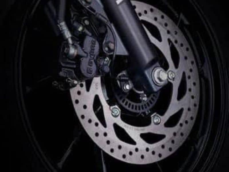 Close-up of a motorcycle's front disc brake and ABS sensor