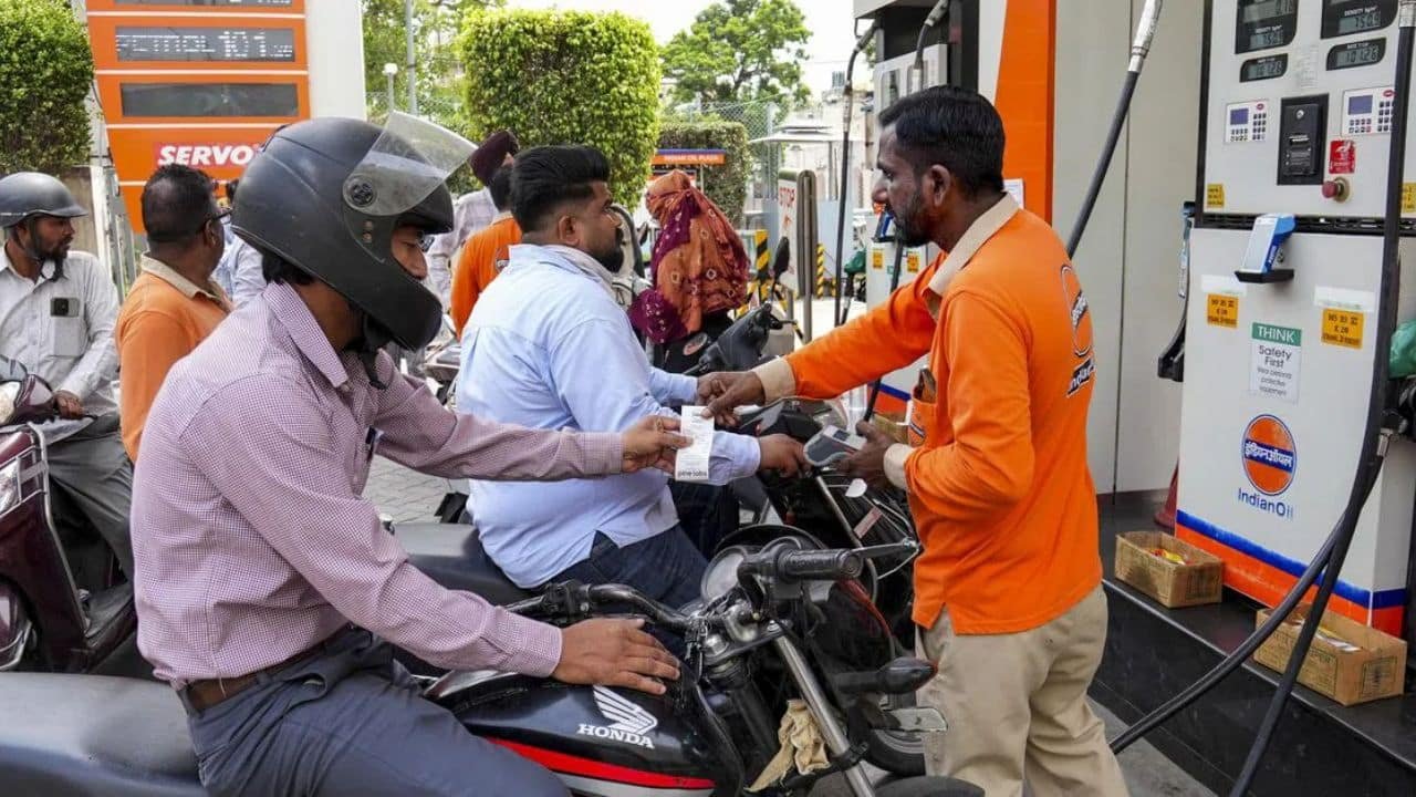 A rider refuelling a petrol motorcycle at an Indian fuel station