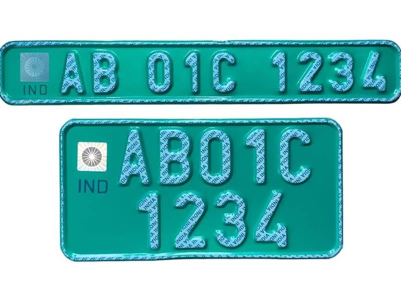 Close-up of an Indian electric vehicle's green number plate with white lettering