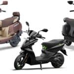 Row of electric scooters including the TVS iQube, Bajaj Chetak and Ather 450 parked at an Indian dealership showroom floor.