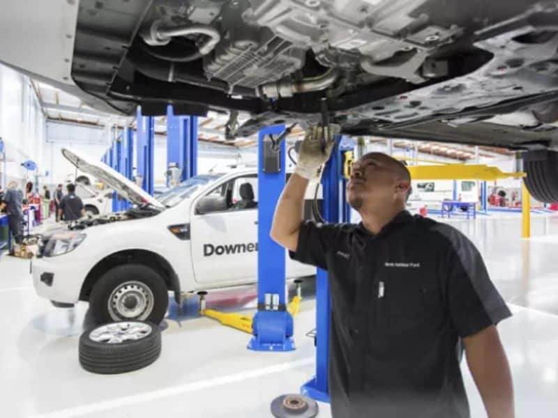 Technician checking high-voltage battery coolant on a Tata electric vehicle during service