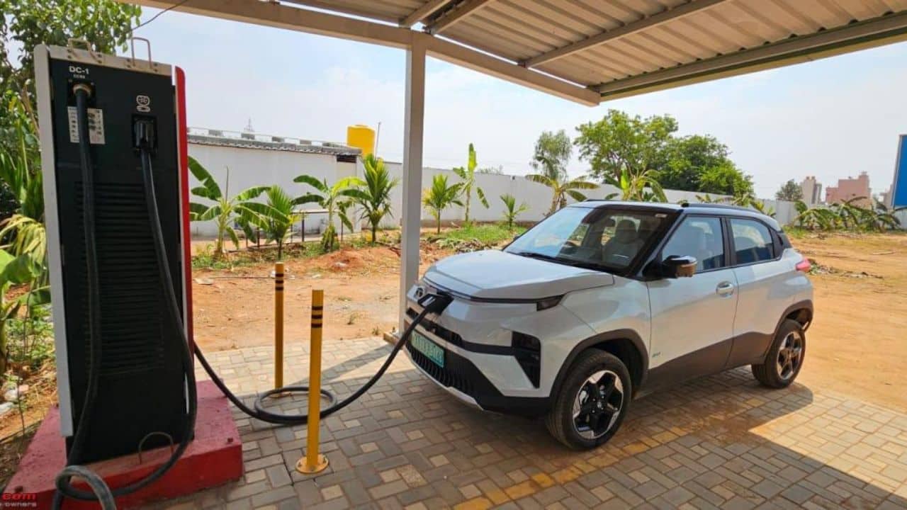Electric SUV plugged into a public charging station in an Indian city, representing India's growing EV car market in July 2026.