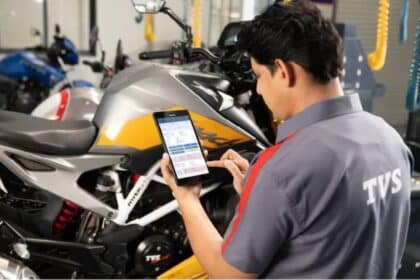 Mechanic inspecting a motorcycle engine at an authorized service center in India