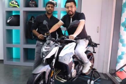 A rider test riding a motorcycle outside an Indian dealership showroom